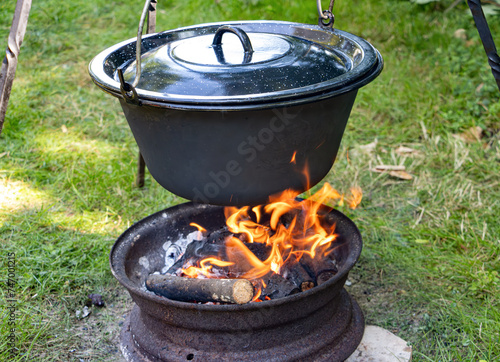 Cooking in a cauldron on an open fire in nature