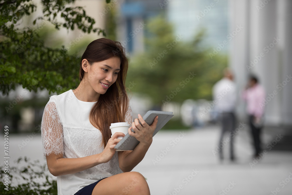 Asian business woman using a digital tablet. Asian business woman using a digital tablet.