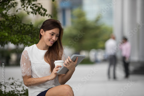 Asian business woman using a digital tablet.