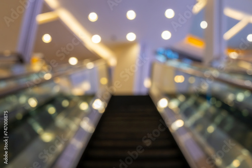 A blurred image of an inclining escalator inside a luxurious shopping mall