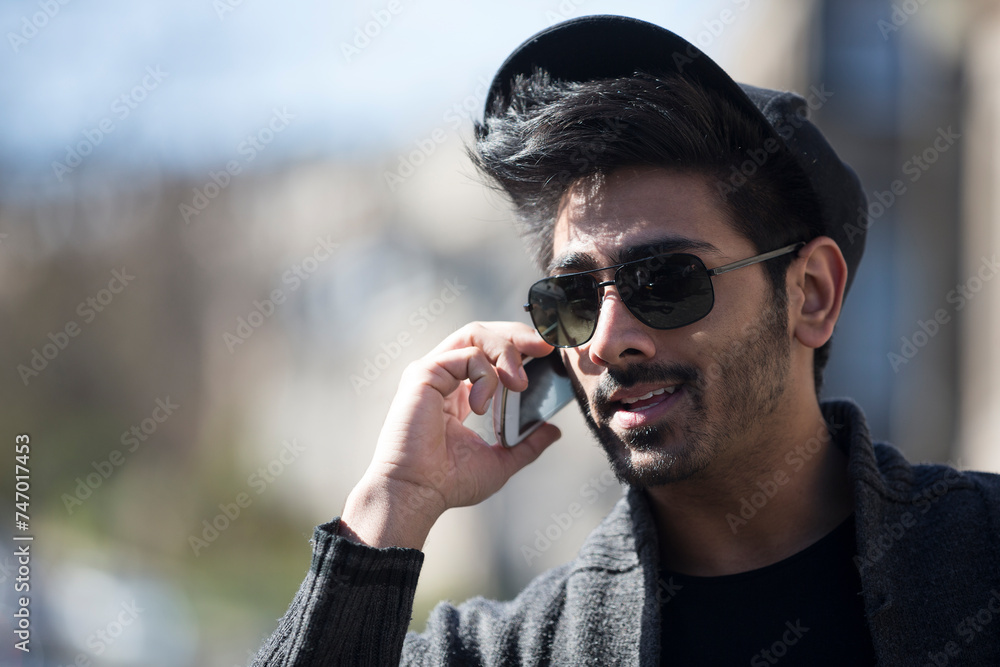 Indian Man standing in city takling on phone. Indian Man standing in city takling on phone.