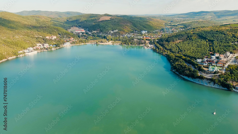 Abrau-Diurso, Krasnodar Krai, Russia. Lake Abrau. Embankment and village. Summer. Fields with vineyards on the hills, Aerial View