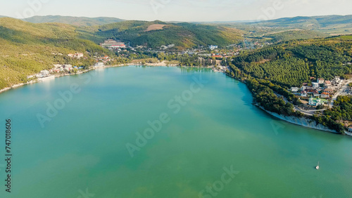 Abrau-Diurso, Krasnodar Krai, Russia. Lake Abrau. Embankment and village. Summer. Fields with vineyards on the hills, Aerial View photo
