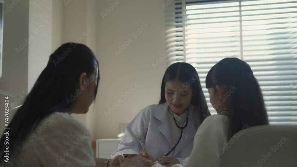 Female doctor examines sick girl's health and gives medical advice to her mother at a modern hospital Ready to give advice on case examination Female doctor examines sick girl's health and gives medical advice to her mother at a modern hospital Ready to give advice on case examination
