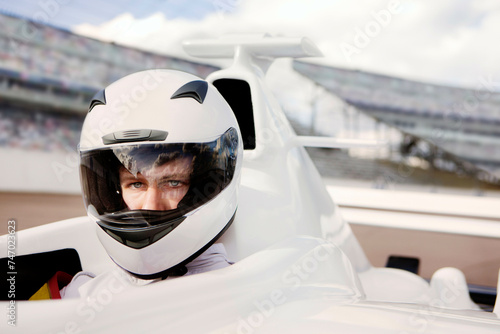 Focused pilot in a racing helmet behind the wheel of a highspeed car on the track  photo