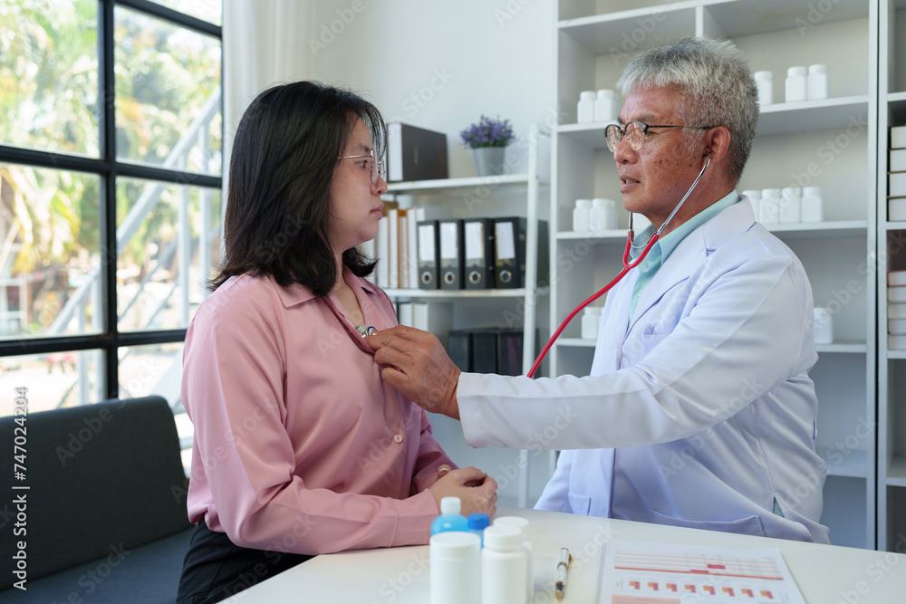 Obraz premium An elderly medical professional uses a stethoscope to listen to a patient's heartbeat and pulse. Before planning treatment, medicines, service concepts health care health insurance.