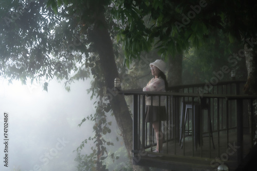 Asian Tourist women On the wooden walkway with Foggy forest Beautiful landscape Scenic view of misty mountain nature background. in Chiang Mai, Thailand