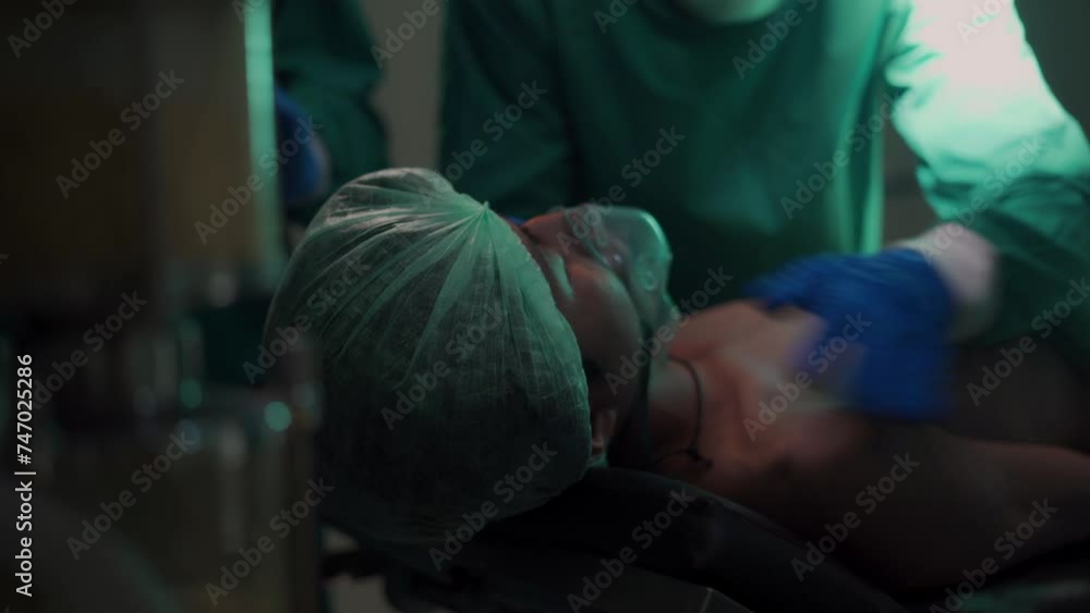 A professional medical team in the operating room helps the patient ...