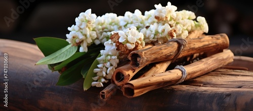 A collection of white Kra Jiew flowers elegantly arranged on a wooden piece, creating a simple yet beautiful display.