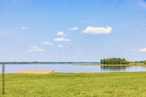 Fototapeta Naklejka Na Ścianę i Meble -  Scenic landscape view of a calm lake a sunny summer with a blue sky
