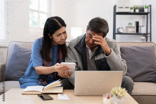 Serious stressed asian senior old couple worried about bill discuss unpaid bank debt paper payment worry about money problem photo