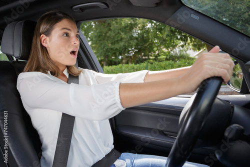 shocked woman while steering her car © auremar