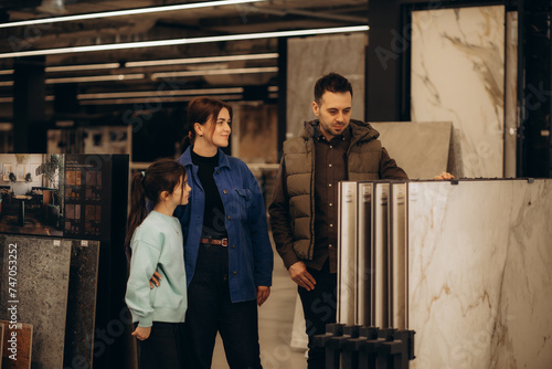 a family with children chooses tiles in a hardware store