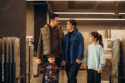 a family walks through a construction supermarket. dad, mom, two sons and a daughter are walking in a hardware store