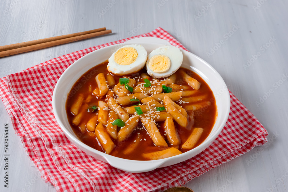 topokki or tteokbokki with two boiled eggs on a white plate and on a white background. perfect for recipes, articles, catalogues, commercials or any cooking content. topokki or tteokbokki with two boiled eggs on a white plate and on a white background. perfect for recipes, articles, catalogues, commercials or any cooking content.