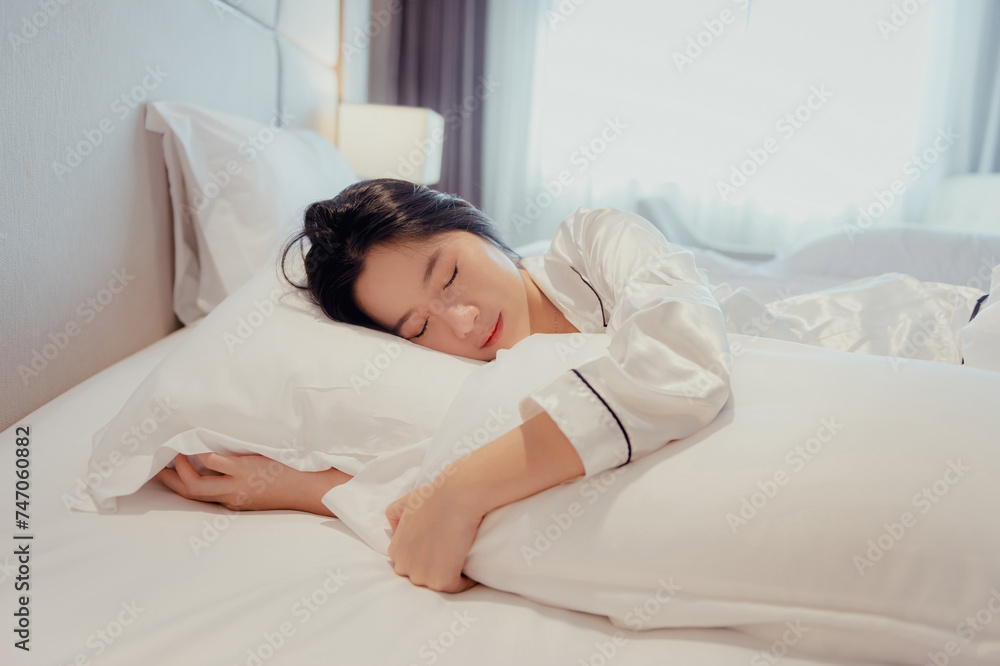 Asian teenage girl resting on the mattress After a full night's sleep And working in the morning in the bedroom. She is cheerful, bright, and happy. Asian teenage girl resting on the mattress After a full night's sleep And working in the morning in the bedroom. She is cheerful, bright, and happy.