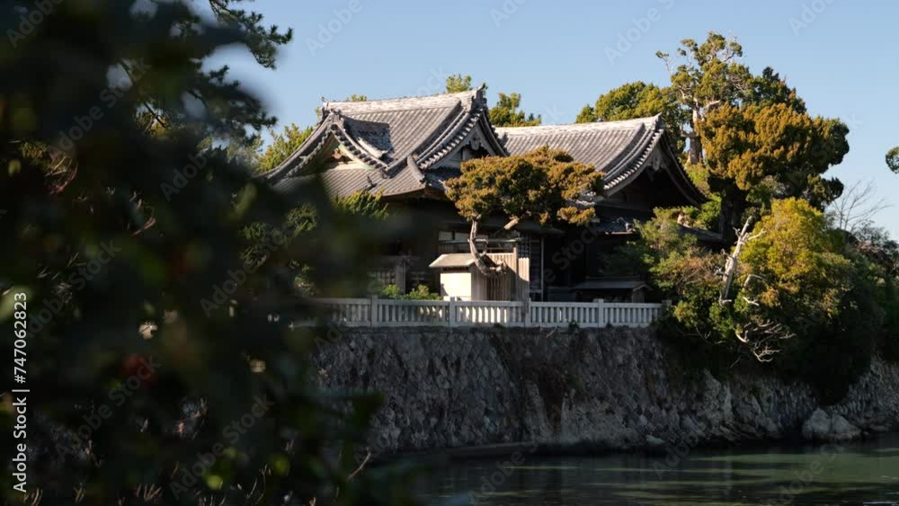 Beautiful Japanese ancient shrine surrounded by trees on calm day Beautiful Japanese ancient shrine surrounded by trees on calm day