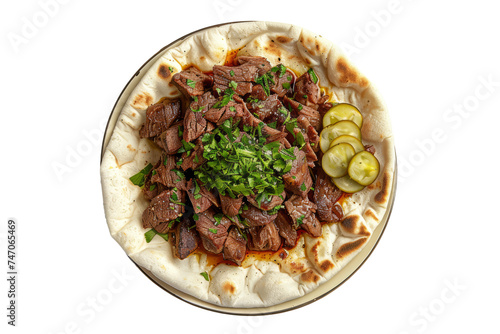 top view of a Lebanese shawarma plate, featuring thinly sliced marinated meat (usually lamb, beef, or chicken), served with garlic sauce, pickles, and flatbread.