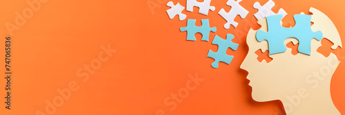 Paper human head with puzzle pieces on orange background with space for text. Logic concept photo