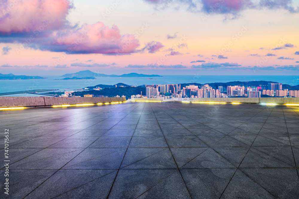 Empty square floor and city skyline with beautiful coastline landscape at sunset