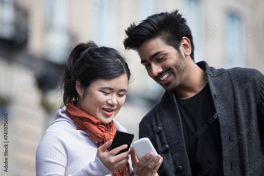 Happy Asian friends looking at smartphone's. Happy Asian friends looking at smartphone's.
