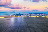 Empty square floor and city skyline with beautiful coastline landscape at sunset