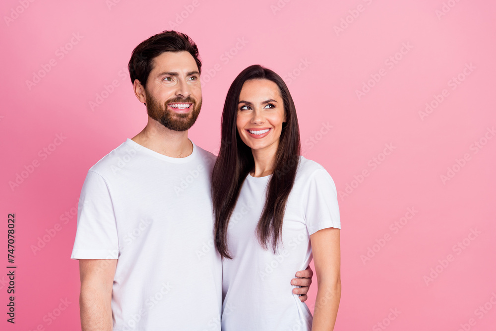 Photo portrait of lovely young couple hugging look empty space wear trendy white garment isolated on pink color background Photo portrait of lovely young couple hugging look empty space wear trendy white garment isolated on pink color background
