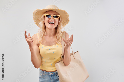 Portrait of cool elderly lady making rock n roll gesture with fingers with joyful expression