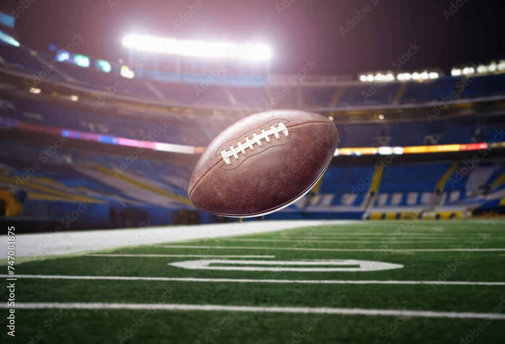 American football ball in flight against the background of the stadium