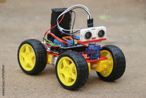 Programmable robotic car built using micro controller and ultrasonic distance sensor along with servos and dc motor. Working prototype of a car