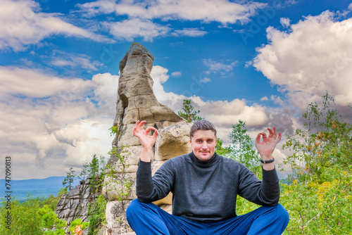 young handsome man on a rock on the Arakul shihan enjoys on a summer day photo