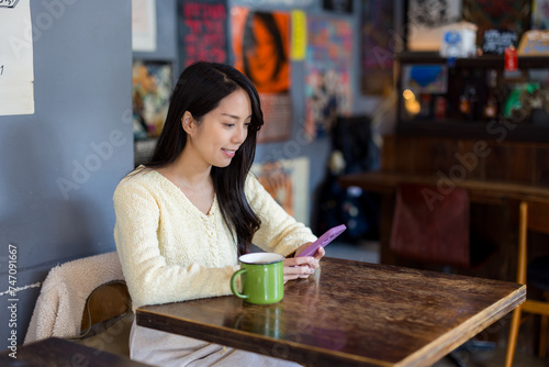 Woman use smart phone inside coffee shop