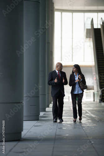 Happy Indian Business colleagues walking outside office.
