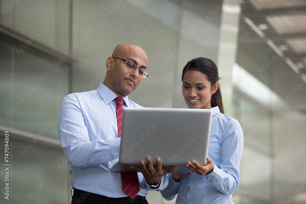 Indian business people looking at a laptop Indian business people looking at a laptop