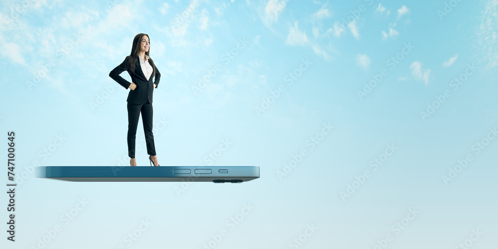 A professional woman in a suit stands confidently on a giant smartphone, symbolizing connectivity and business mobility A professional woman in a suit stands confidently on a giant smartphone, symbolizing connectivity and business mobility