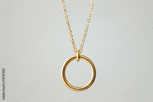 A minimalist gold necklace consisting of a single perfectly formed loop capturing the essence of elegance in its simplicity The necklace hangs against a stark white background