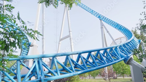 Roller coaster Ride against blue sky. Roller coaster in the amusement park. Cheerful entertainments in park of attractions