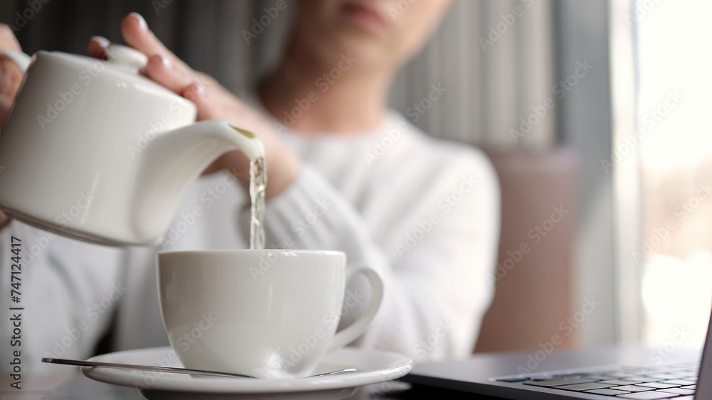 A woman sits in a pub and enjoys a cup of hot aromatic drink during her afternoon break. Concept of various types of tea, tea drinking and relaxation A woman sits in a pub and enjoys a cup of hot aromatic drink during her afternoon break. Concept of various types of tea, tea drinking and relaxation