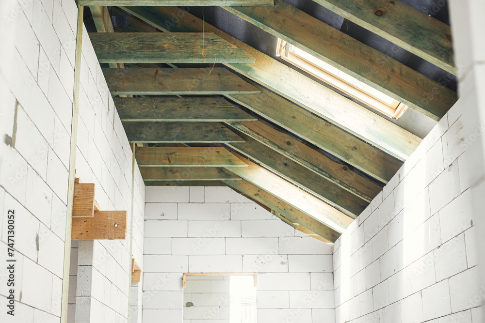 Unfinished attic wooden roof framing with vapor barrier, dormer and ...