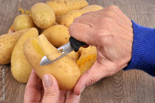 Pomme de terre épluchée avec un économe en gros plan photo