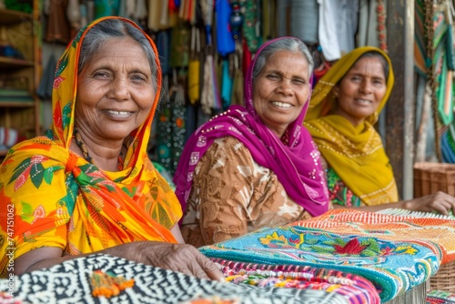 Smiling Elderly Women in Colorful Traditional Attires Sitting Together at a Local Market Stall