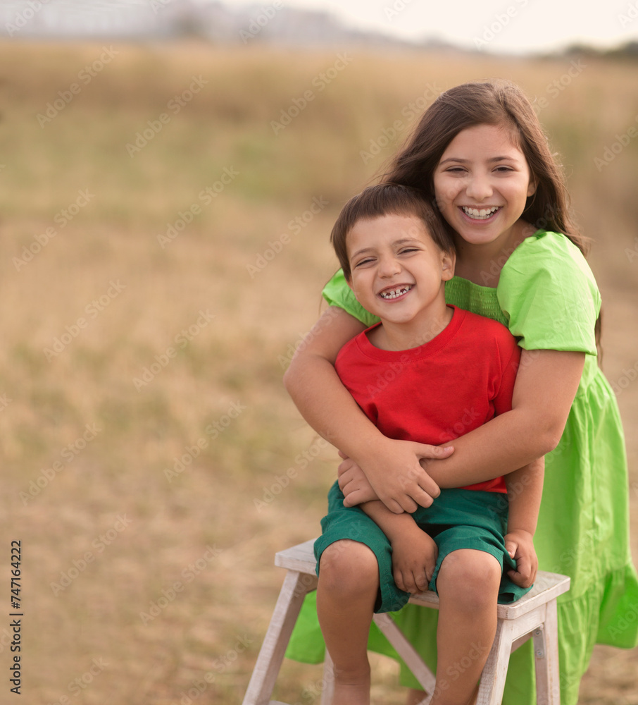 Fototapeta premium children brother and sister embrace summer day on the field. copy space. summer time in nature in the village