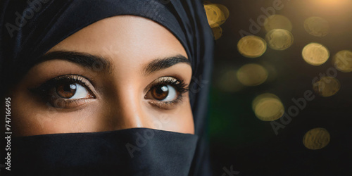 close up of eyes of Muslim woman in hijab and copy space on the dark photo