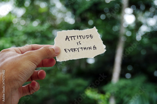 attitude is everything - Hand holding torn paper motivational slogan Inspirational Typography Quote on torn paper