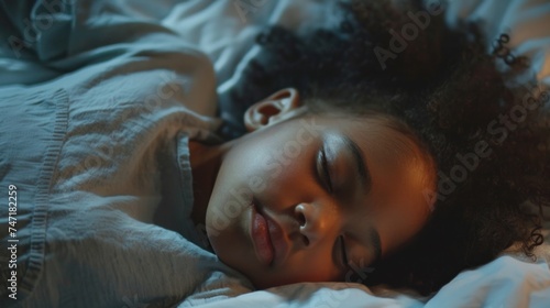 A peaceful scene of a young child with curly hair sleeping soundly on a bed with soft light-colored bedding.