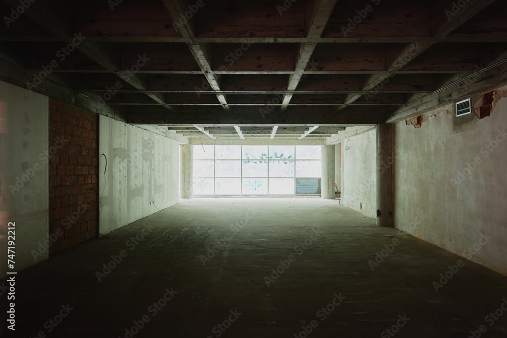 a empty room with windows and lights shining through the gap