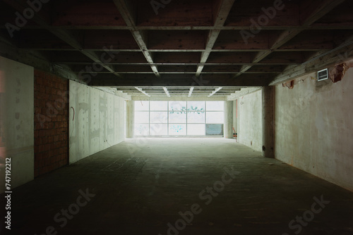 a empty room with windows and lights shining through the gap