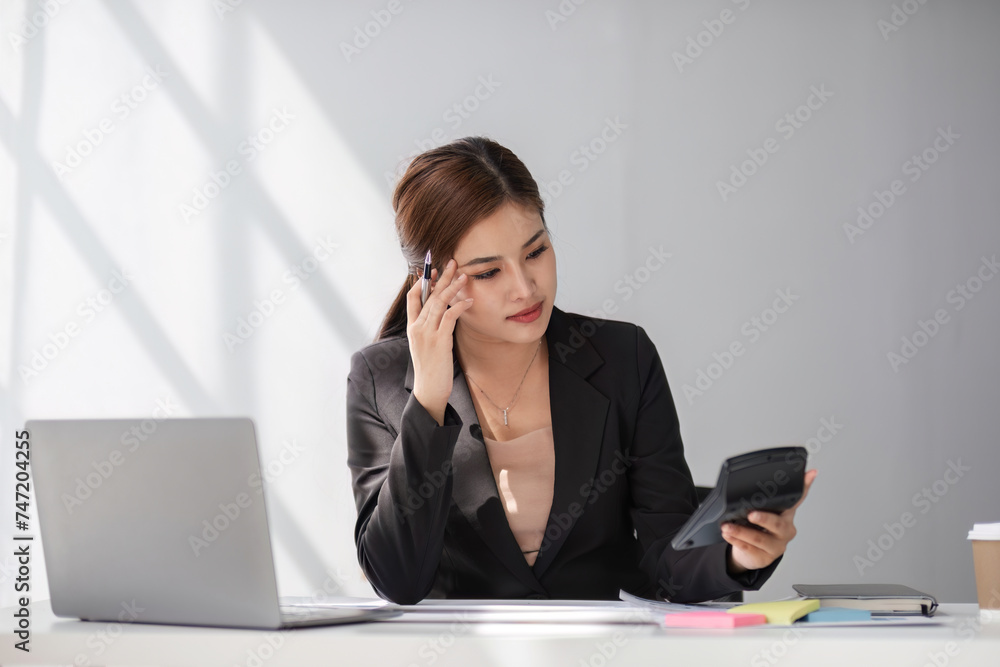 Young business woman with stress working in the office Sitting and working in front of a laptop, discussing work that is having problems. Young business woman with stress working in the office Sitting and working in front of a laptop, discussing work that is having problems.