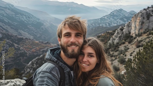 Man and woman on a mountain taking bright selfie