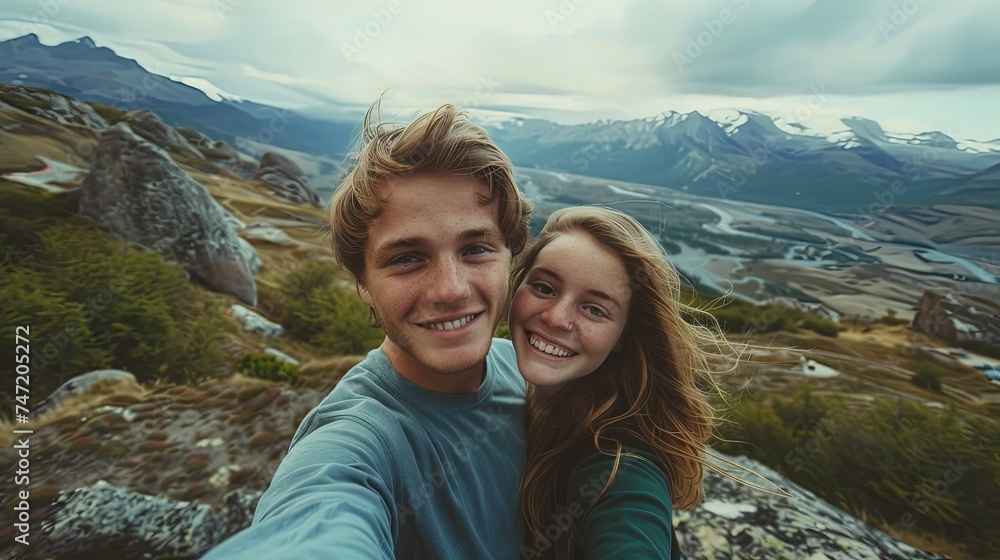 Man and woman on a mountain taking bright selfie Man and woman on a mountain taking bright selfie